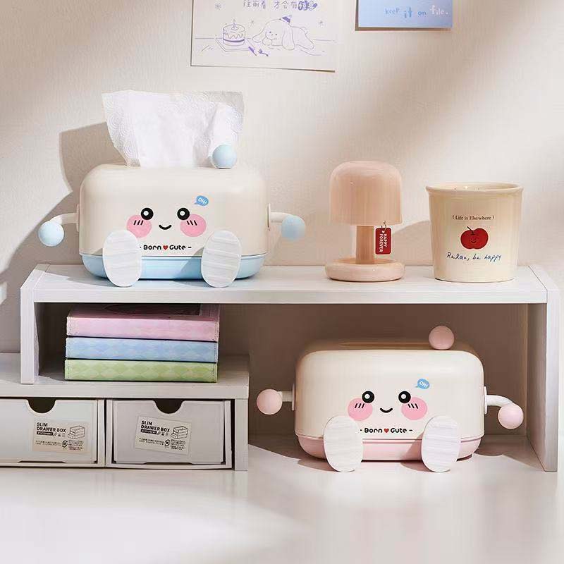 Cute cartoon-themed storage boxes on a shelf with books and a lamp.