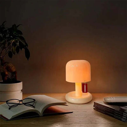 Small lamp on a table with an open book and glasses, creating a warm glow.