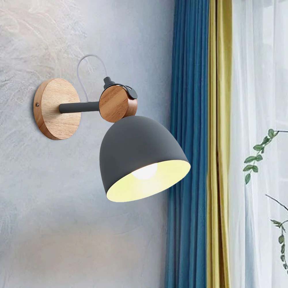 Wall-mounted lamp with wooden fixture and gray shade on a light gray wall.