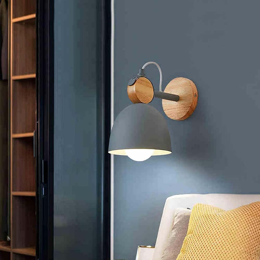 Wall-mounted lamp with wooden accents on a blue wall next to a bookshelf and sofa.