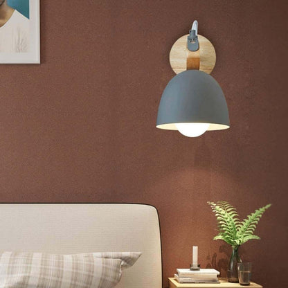Wall-mounted lamp with a brown wall and bed in the background