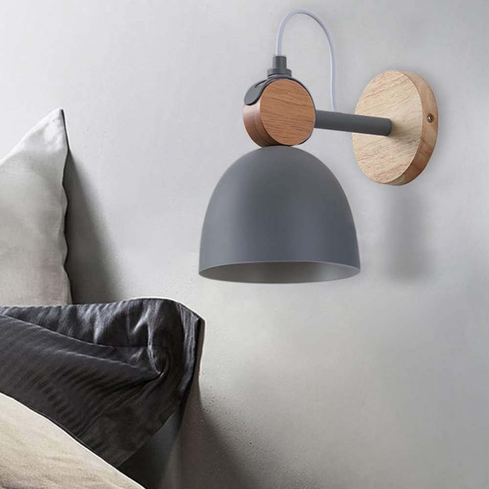 Wall-mounted lamp with gray shade and wooden arm on a light gray wall.