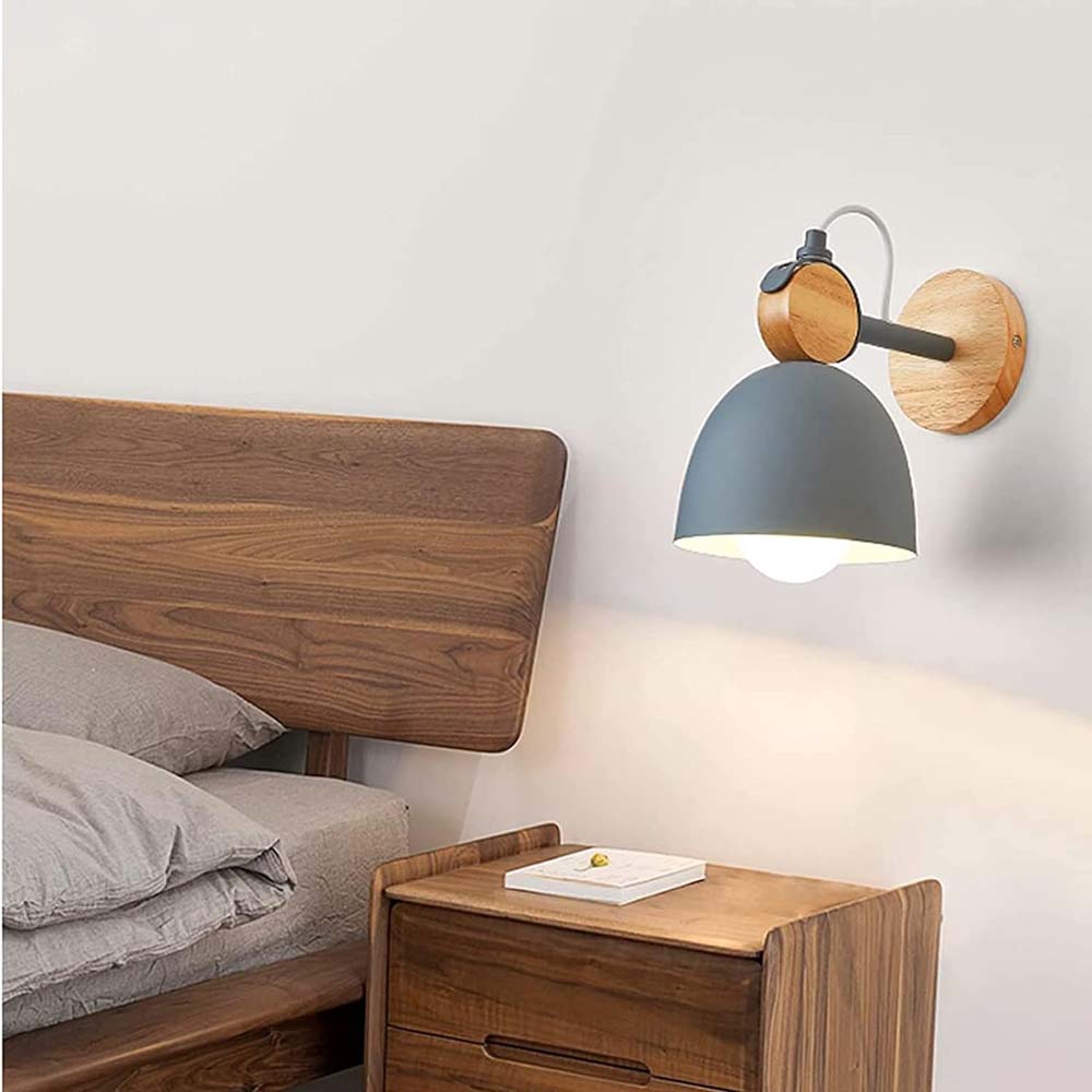 Wooden headboard and nightstand with a wall-mounted lamp in a bedroom setting.