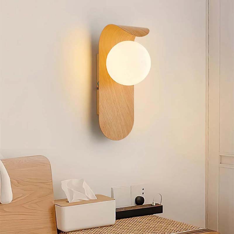 Wall lamp with a round bulb on a neutral wall.