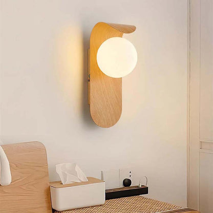 Wall lamp with a round bulb on a neutral wall.
