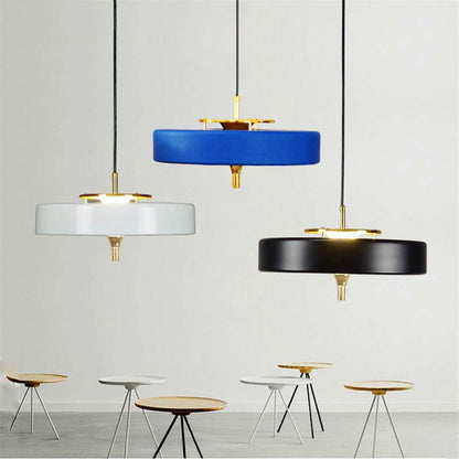 Three pendant lights in blue, white, and black with gold accents on a light gray background.