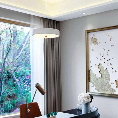 White Minimalist LED Pendant Lamp in a modern home office with a large window, desk, and decorative wall art.
