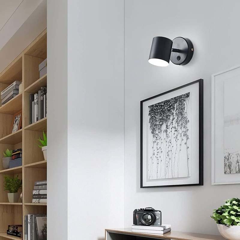 Modern wall light fixture on a white wall with decor elements.