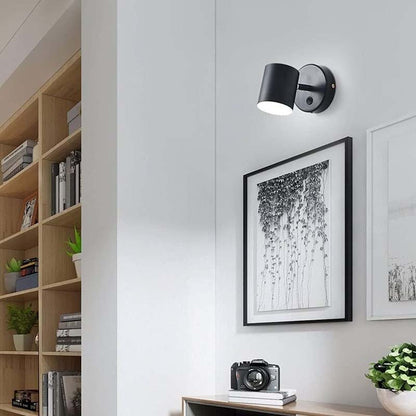 Modern wall light fixture on a white wall with decor elements.