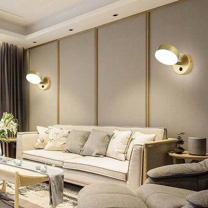 Modern living room with beige sofa, decorative pillows, and wall lights.