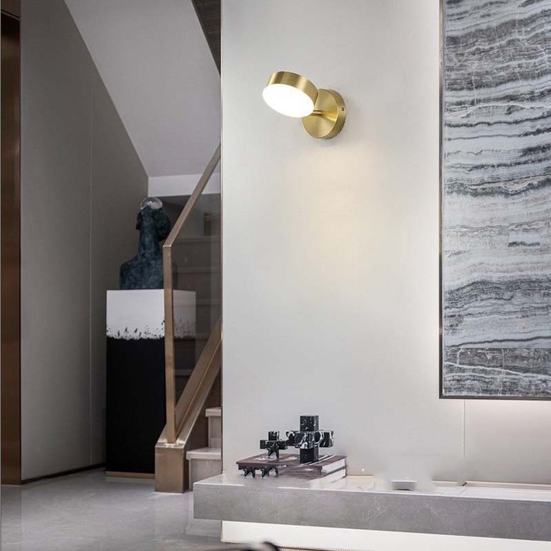 Modern interior with a gold wall sconce, abstract painting, and decorative items.