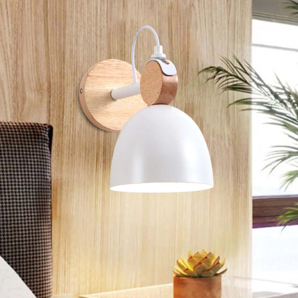 Wall-mounted lamp with wooden fixture and white shade in a room setting.
