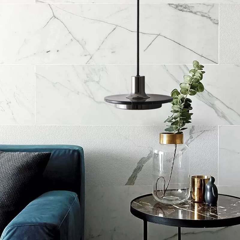 Modern Marble Pendant Light in a contemporary interior with a turquoise sofa, marble wall and decorative table.