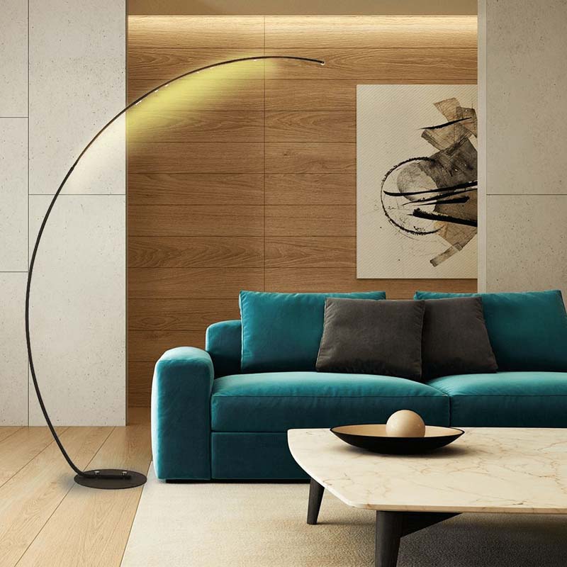 Modern arc floor lamp in a living room with a blue sofa and an abstract painting