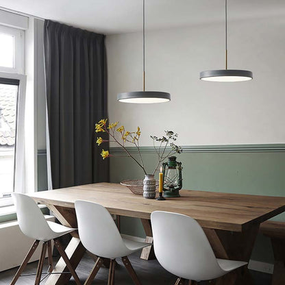 Dining area with a wooden table and white chairs, featuring pendant lights and a window.