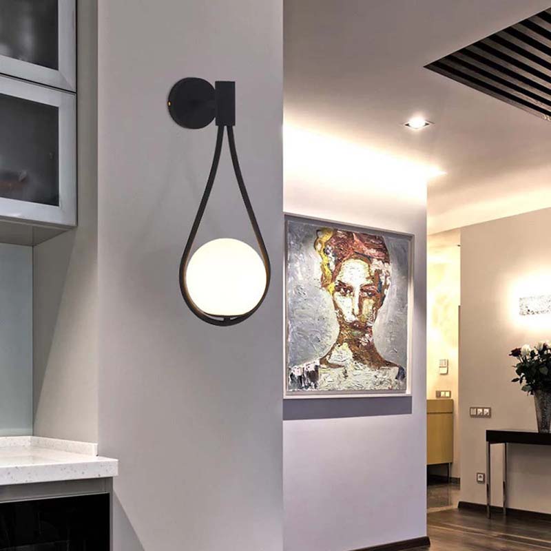 Modern wall light fixture in a stylish interior setting with artwork on the wall.