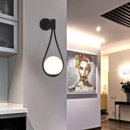 Modern wall light fixture in a stylish interior setting with artwork on the wall.