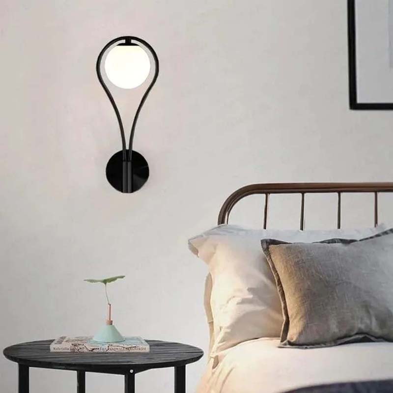 Modern wall sconce above a bed in a bedroom setting