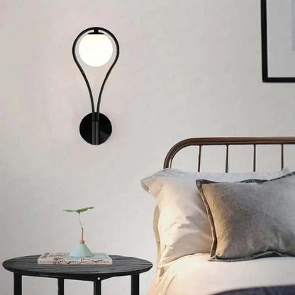 Modern wall sconce above a bed in a bedroom setting