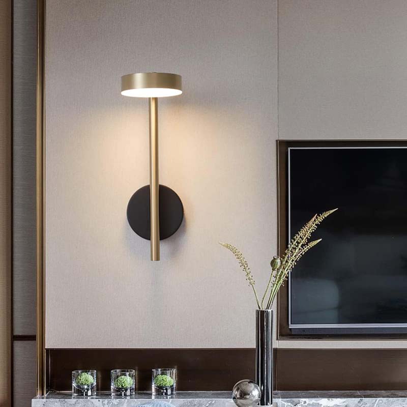 Modern wall sconce mounted near a television screen.