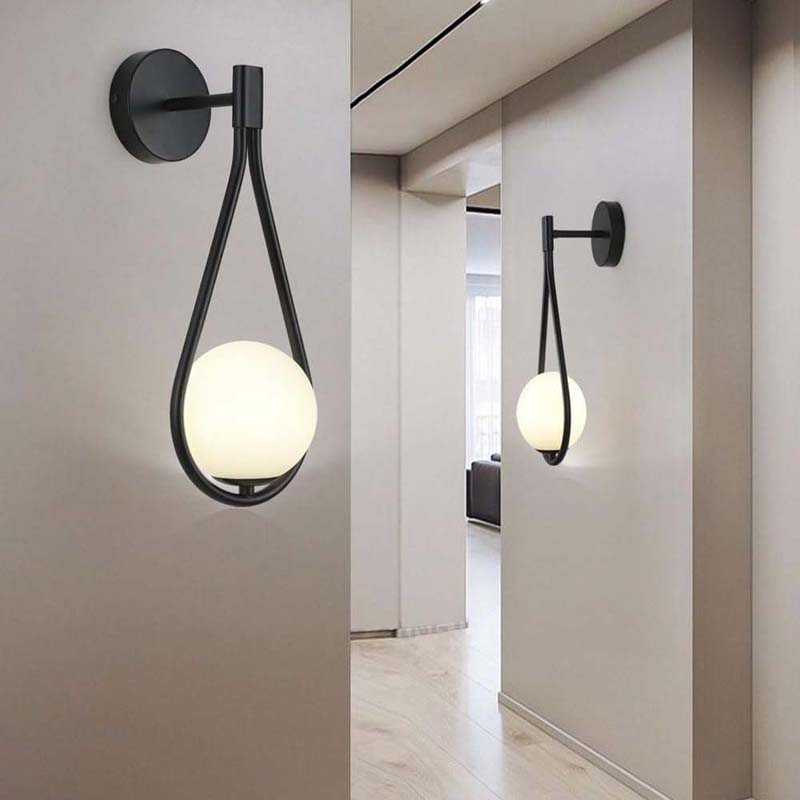 Modern wall sconces with spherical glass shades in a minimalistic interior setting.