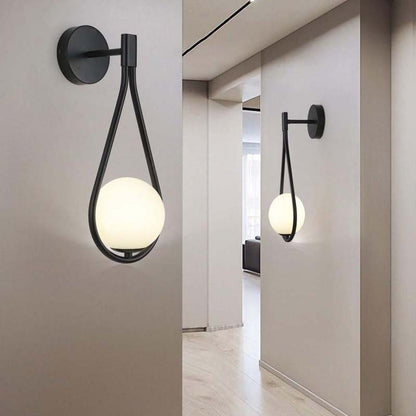 Modern wall sconces with spherical glass shades in a minimalistic interior setting.