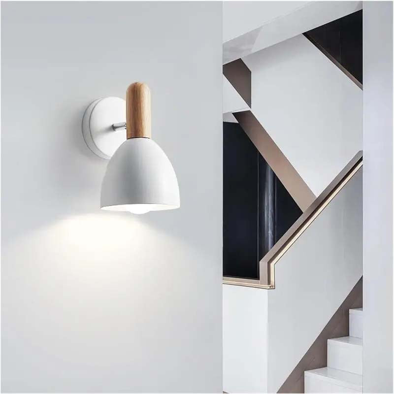 Modern wall-mounted light fixture with wooden accent on a white wall.