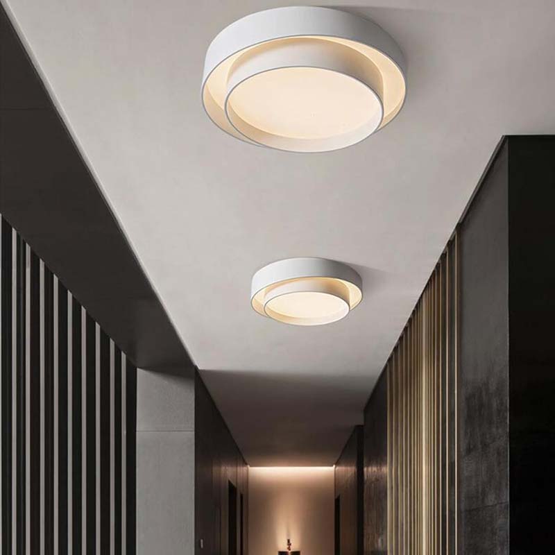 Two modern ceiling lights on a white ceiling with a dark hallway in the background.