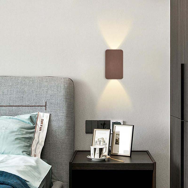 Panel - Minimalist LED Wall Sconce in a modern bedroom with a grey upholstered headboard and dark wood nightstand.