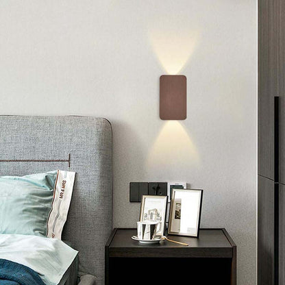 Panel - Minimalist LED Wall Sconce in a modern bedroom with a grey upholstered headboard and dark wood nightstand.
