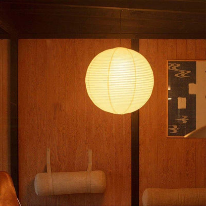 Paper pendant lamp glowing in a warm wooden interior