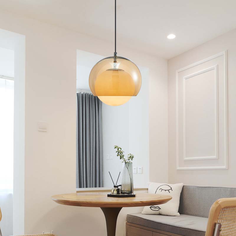 Pendant Globe Light in a modern interior with a round wooden table and a sofa with cushions.