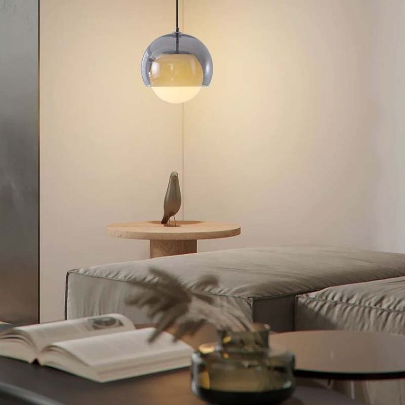 Modern interior with a pendant light, book, and decorative items on a table.