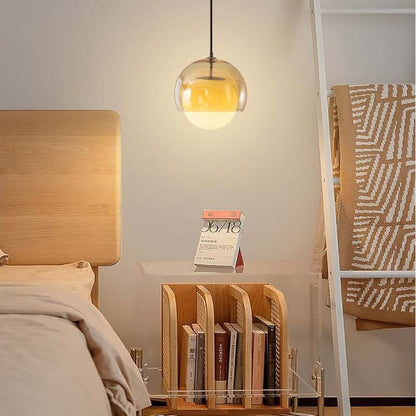Pendant Globe Light in a bedroom with a wooden headboard and a nightstand with books