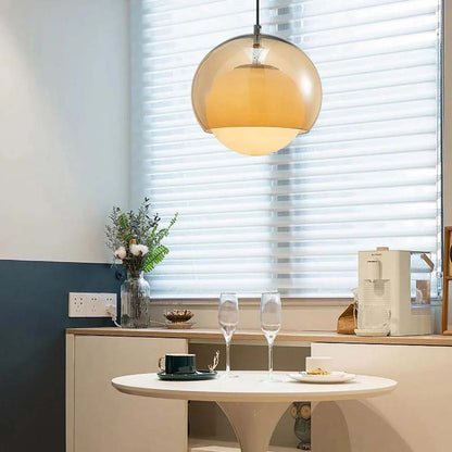 Pendant Globe Light in a modern kitchen with a round table and coffee maker.