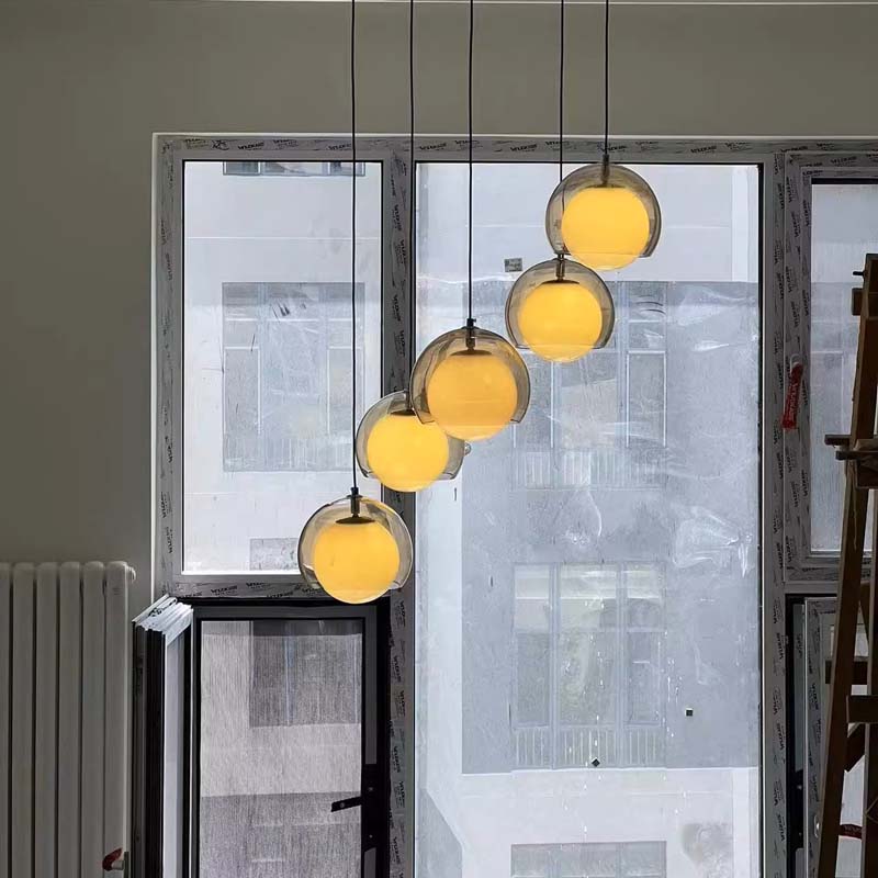 Modern pendant lights hanging in a room with large windows.