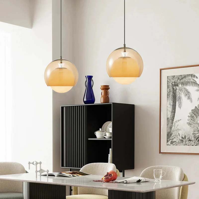Modern dining room with pendant lights, a black cabinet, and decorative items.