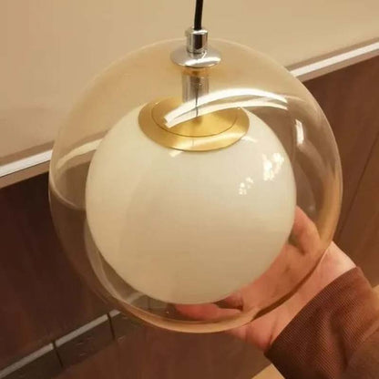 Pendant light with a glass cover held by a person against a neutral background