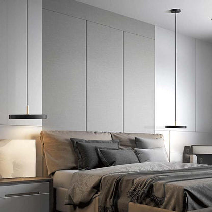 Orbita metal acrylic pendant lamp in a modern bedroom with gray bedding and neutral tones.