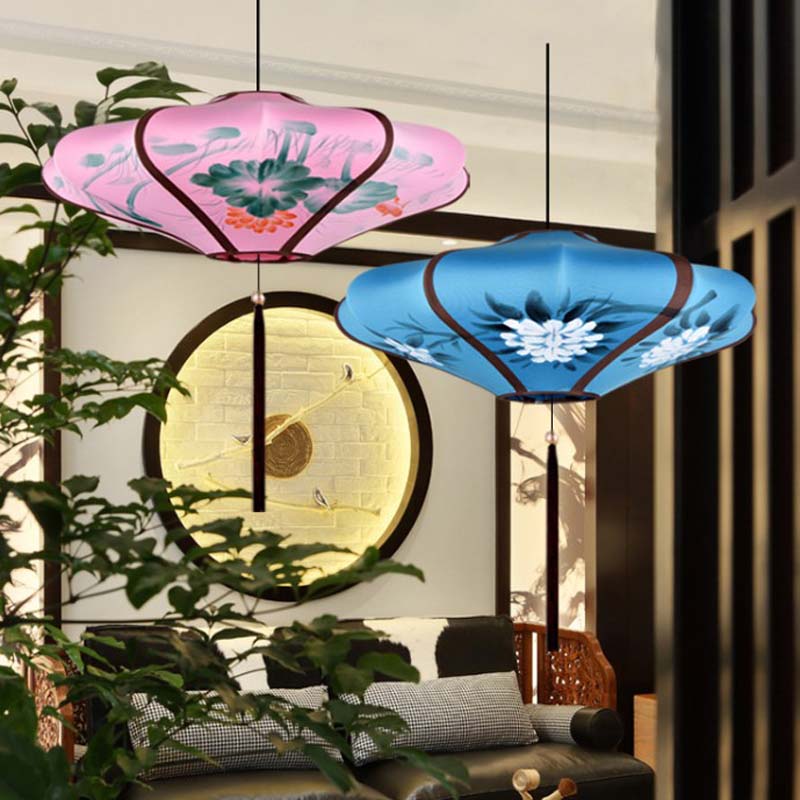 Two decorative ceiling lamps with floral designs in a room with plants and a wall clock.