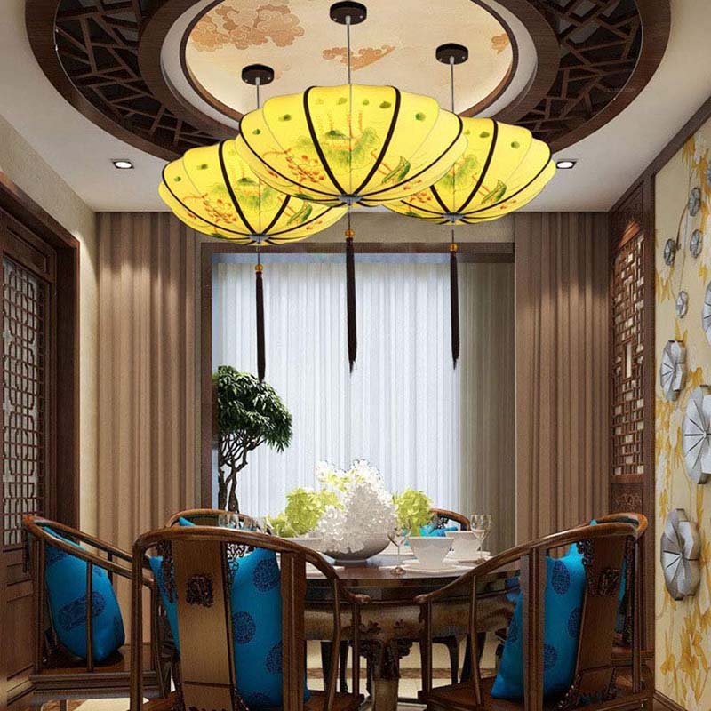 Dining room with a large yellow ceiling light fixture, table, chairs, and decorative elements.