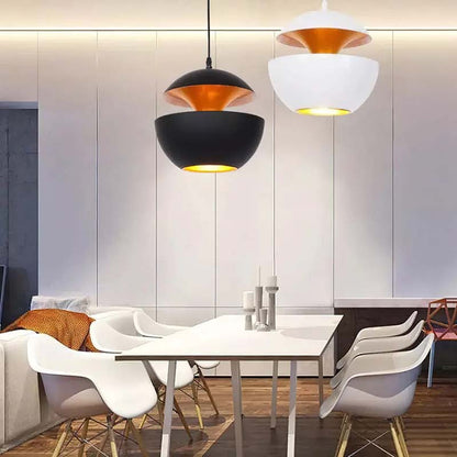Two Fire Sphere pendant lights in black and white hanging above a modern dining table with white chairs