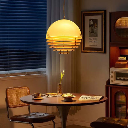 Pendant lamp Sunset with a dome-shaped shade above a round table in a cozy vintage interior.
