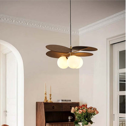 Pendant light with wooden petal elements and frosted glass globes in an interior.