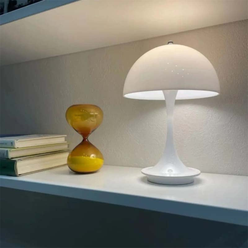 White table lamp on a shelf with books and an hourglass