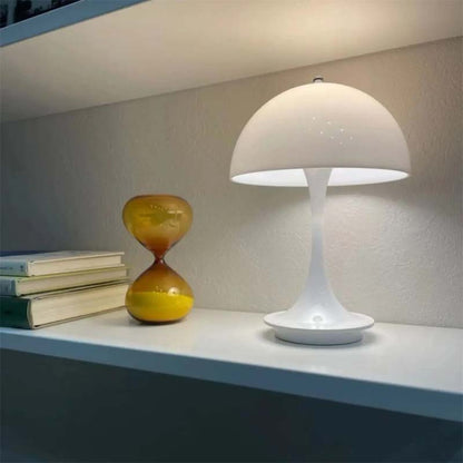 White table lamp on a shelf with books and an hourglass