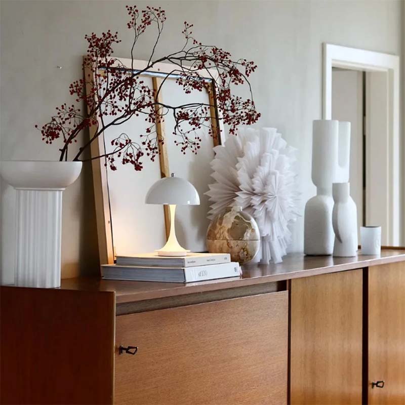 Decorative setup on a wooden surface with books, a lamp, and decorative items.