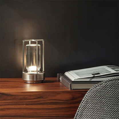 Modern glass table lamp on a wooden surface with a dark background