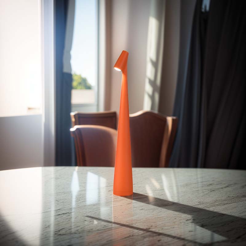 Orange lamp on a marble table with chairs and curtains in the background