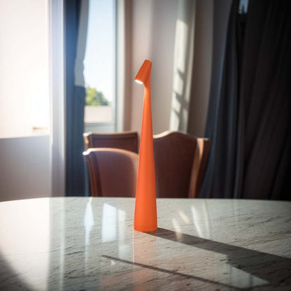 Orange lamp on a marble table with chairs and curtains in the background